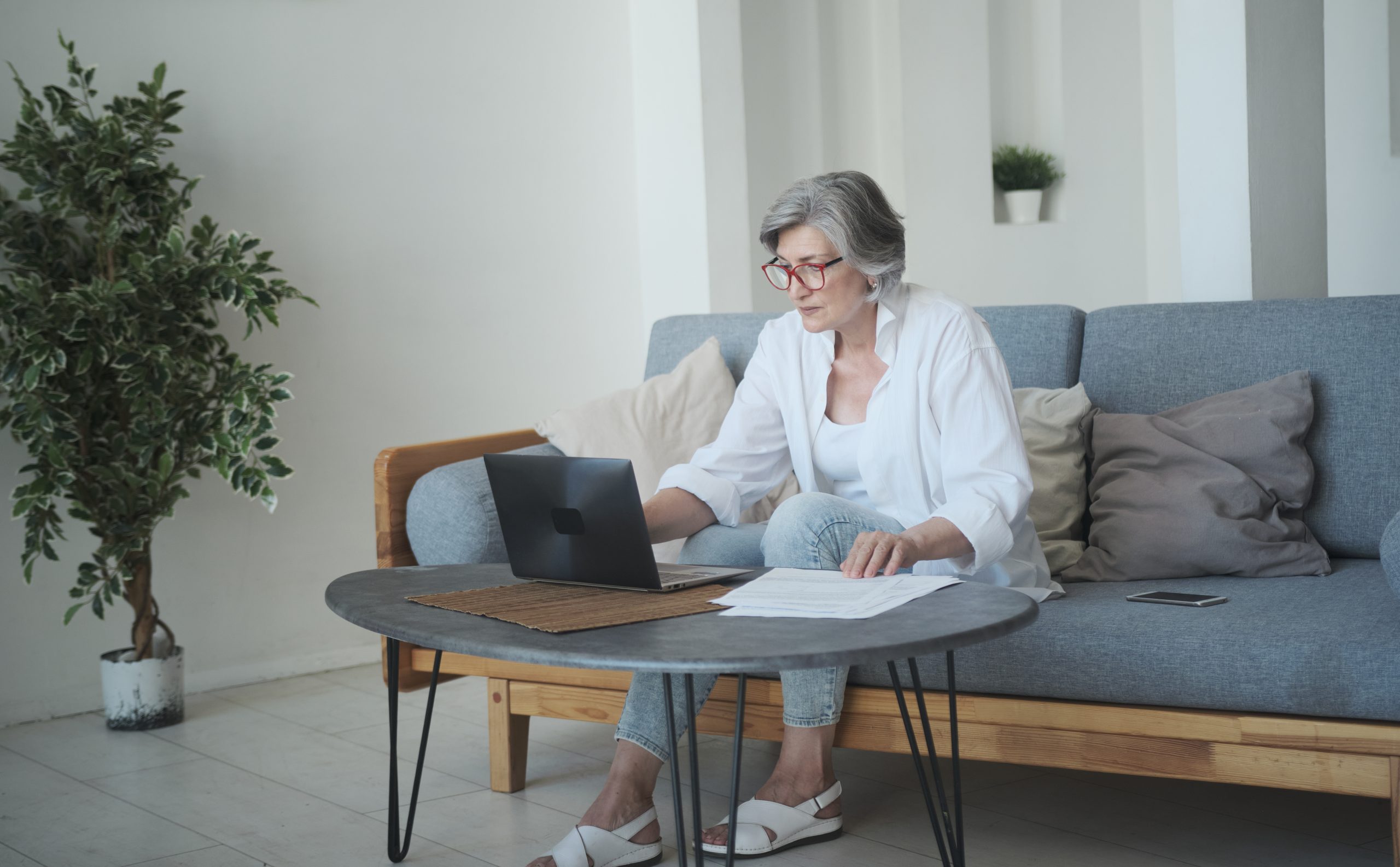 Woman on a couch sitting at her computer