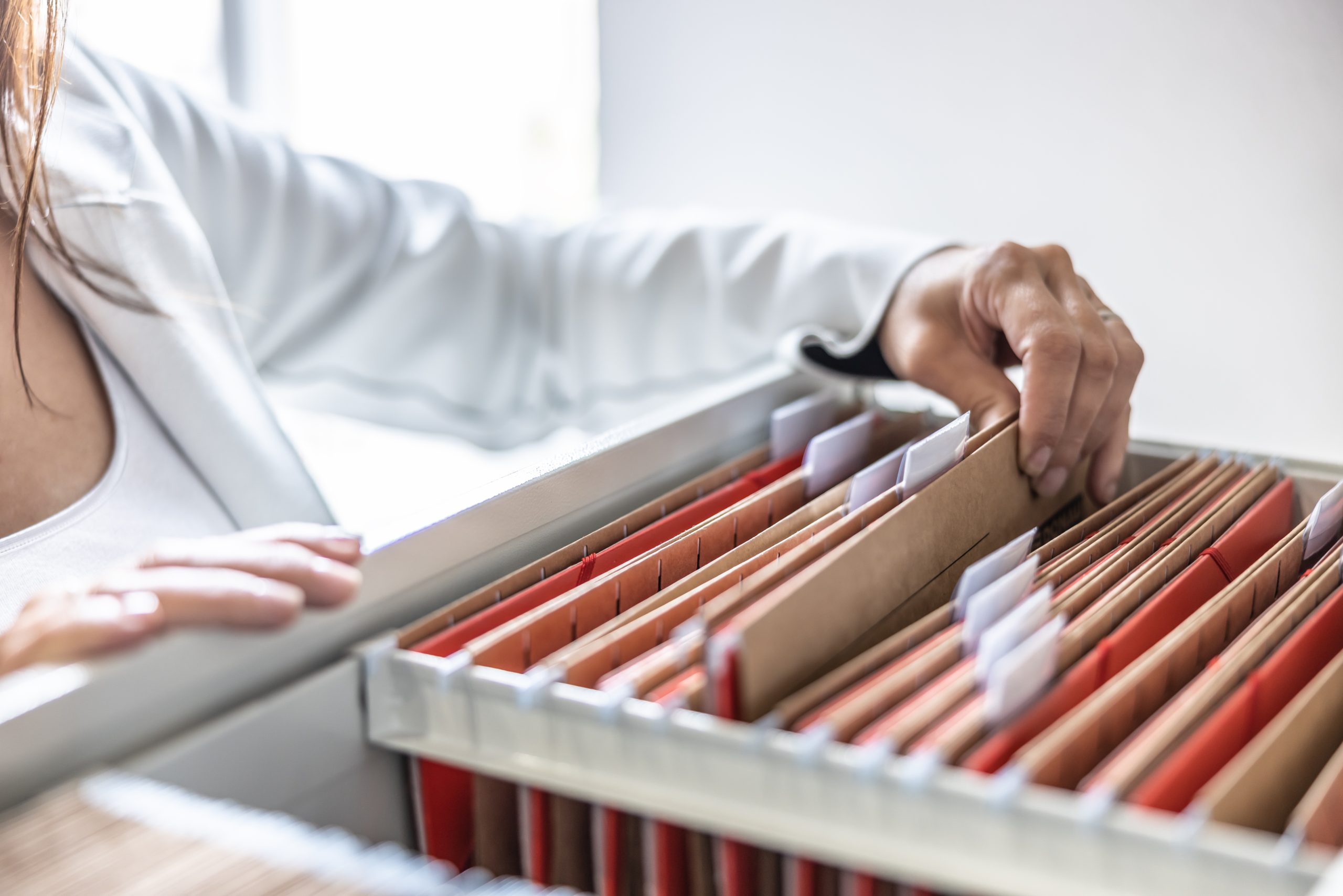 Closeup view of a medical practitioner sorting through files.